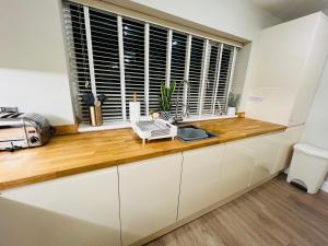 a kitchen with a counter with a sink and a window at The Duplex with Air Conditioning & Private Deck Area in Margate