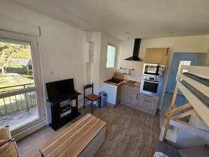 a room with a kitchen with a stove top oven at Studio 3 personnes avec terrasse in Luchon