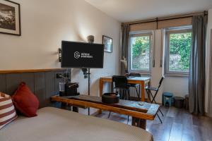 een slaapkamer met een bed en een tv aan de muur bij Outdoor Apartments - Studiò11Centro in Aosta