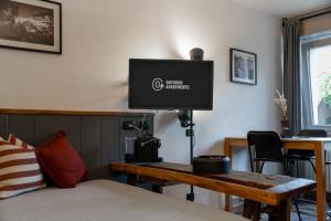 een slaapkamer met een bed en een tv aan de muur bij Outdoor Apartments - Studiò11Centro in Aosta