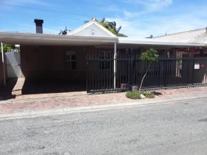 a house with a fence on the side of the street at Tolbos Backpackers in Worcester
