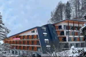 巴库里阿尼bakuriani oasis WINDOW DEVELOPMENT的一座有树木的雪地建筑