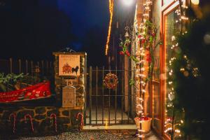 a gate with christmas lights next to a house at Gîte la casa del cookie in Chimay