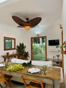 una sala da pranzo con tavolo e ventilatore a soffitto di Casa PauBrasil a Trancoso