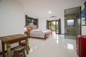 una camera da letto con un letto, un tavolo e delle sedie di Pousada Vista pro mar Ilhabela a Ilhabela Altre 91 foto