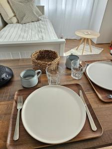 two white plates on a wooden table with a bed at Studio Le Petit Sablé in Concarneau +13 photos