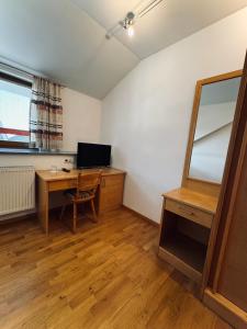 a room with a desk with a mirror and a computer at Landgasthof Hotel Zwickl in Deggendorf