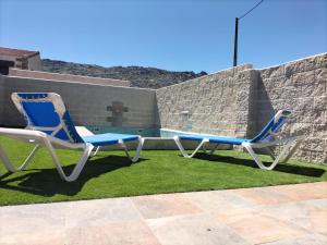 two chairs sitting on the grass next to a pool at Villa pose in Robledillo