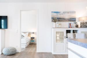 a white kitchen with a door leading into a living room at Seaside 49 3 N in Wangerland