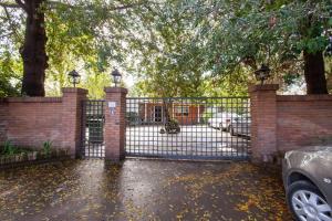 a wrought iron fence with a gate in a yard at Escape al bosque! - Casa Vintage in San Luis +16 photos
