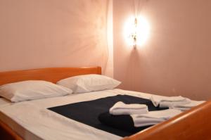 a bed with white pillows and towels on it at Hotel Dva Javora in Jahorina