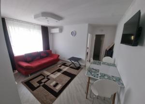 a living room with a red couch and a table at Cavnic Residence 1 in Cavnic