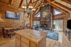 Una cocina y una sala de estar con chimenea en una cabaña de madera. en Overlook at Sleepy Creek -- Sleepy Creek Frontage, Secluded, Grill, Fire Pit, Deck, Family Friendly, Game Room, Fishing, Hammock, View, Fireplace, en Morton Grove