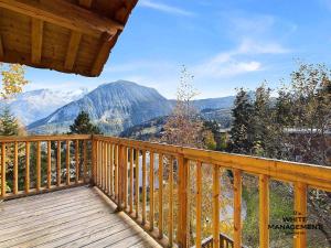 a wooden balcony with a view of mountains at Résidence Le Grand Cerf - Appartement fraichement rénové à Courchevel 1550 MAE-3791 in Courchevel