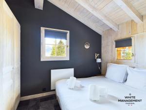 a bedroom with a white bed and a window at Résidence Le Grand Cerf - Appartement fraichement rénové à Courchevel 1550 MAE-3791 in Courchevel