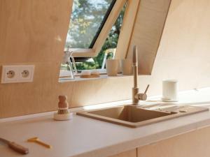 a kitchen counter with a sink and a window at Minimalistyczny domek przy Kampinosie in Przęsławice