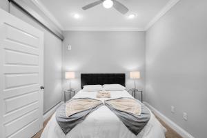 a white bedroom with a bed with two lamps at Stylish 1BR - Rooftop Pool in Philadelphia +40 photos