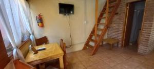 a room with a table and a television on the wall at Cabaña BIKO in El Bolsón