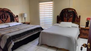 a bedroom with two beds and a window at Hotel Chely in Bernal