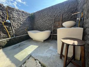 bagno con vasca e sgabello. di Di Kubu YR a Jembrana
