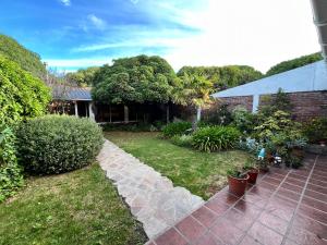 a garden with plants and a brick house at CHALET CERCA DEL VIVERO y DEL MAR in Miramar