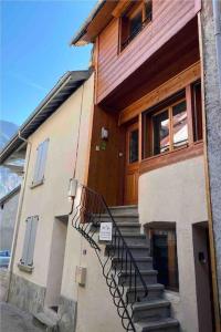 ein Haus mit einer Treppe vor einem Gebäude in der Unterkunft Maison de Bergers, Cyclist & Ski Friendly Town House, WIFI, Secure Bike Store in Le Bourg-dʼOisans