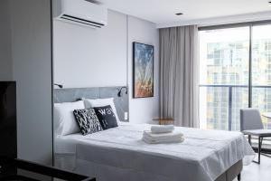 a white bedroom with a bed and a large window at Way Tambaú #H6 - Triplo Deluxe por Carpediem in João Pessoa +34 photos