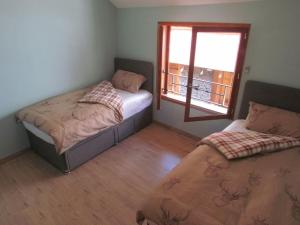 ein Schlafzimmer mit zwei Betten und einem Fenster in der Unterkunft Maison de Bergers, Cyclist & Ski Friendly Town House, WIFI, Secure Bike Store in Le Bourg-dʼOisans