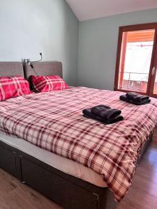 ein Schlafzimmer mit einem Bett mit zwei schwarzen Schuhen darauf in der Unterkunft Maison de Bergers, Cyclist & Ski Friendly Town House, WIFI, Secure Bike Store in Le Bourg-dʼOisans