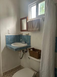a bathroom with a sink and a toilet at Habitación Coco in Holbox Island