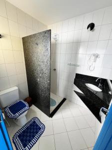 a bathroom with a shower and a sink and a toilet at Pé na areia apto Rassy in Itapoa +26 photos