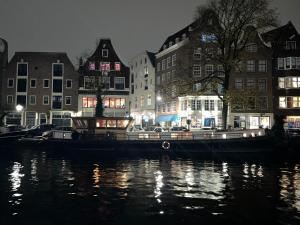アムステルダムにあるWoonboot Josjaの夜の建物前の水上船
