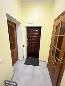 a hallway with two doors and a tile floor at Cozy apartment in Liepāja