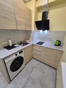 a kitchen with a washing machine and a sink at Cozy apartment in Liepāja