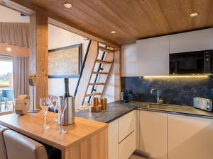 a kitchen with two wine glasses on a wooden counter at Appartement spacieux avec spa, 4 chambres, parking, Les Saisies - FR-1-810-26 in Les Saisies