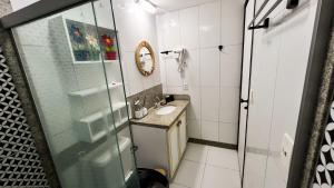 ein Badezimmer mit Waschbecken und Glasdusche in der Unterkunft Muro Alto -Flat - Porto de Galinhas Beira mar in Porto De Galinhas