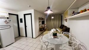 a kitchen and dining room with a table and a refrigerator at Muro Alto -Flat - Porto de Galinhas Beira mar in Porto De Galinhas