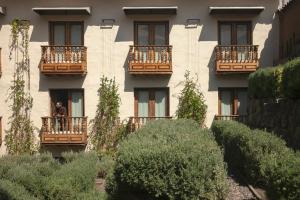 a man standing on a balcony of a building at Antigua Casona San Blas in Cusco
