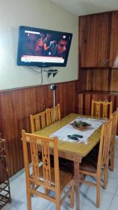 een eettafel met een televisie aan de muur bij Nono110 in Villa Gesell