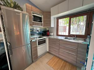 a kitchen with stainless steel appliances and wooden cabinets at Parrot Cage - the Gay Villa in Playa del Ingles