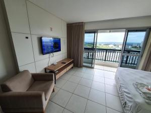 a hotel room with a bed and a couch and a television at Flat Vision Executivo Premium By Rei dos Flats in Brasilia