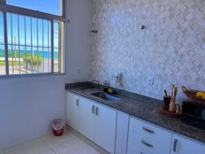 een keuken met een spoelbak en uitzicht op de oceaan bij VISTA PARA MAR - Guarapari ES in Guarapari +38 foto's
