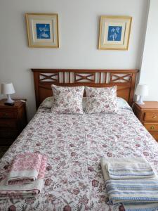 a bedroom with a bed with a floral bedspread at APARTAMENTO LA GRANJA EN GAMA(next to Santoña) in Gama +23 photos