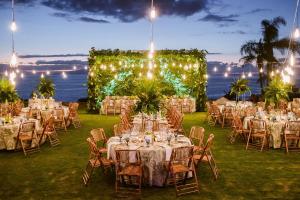 a wedding reception with tables and chairs in the grass at The Ritz-Carlton Tenerife, Abama in Guía de Isora +37 photos