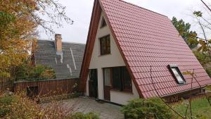 阿伦斯霍普Ferienhaus-Fischlandde Grünbaum Ahrenshoop的一座红色屋顶和围栏的房子