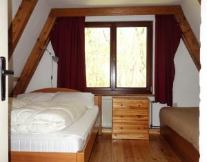 阿伦斯霍普Ferienhaus-Fischlandde Grünbaum Ahrenshoop的一间卧室，里面有一张床和一扇大窗户。