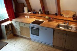 阿伦斯霍普Ferienhaus-Fischlandde Grünbaum Ahrenshoop的带水槽和炉灶的厨房 顶部烤箱 更多6张照片