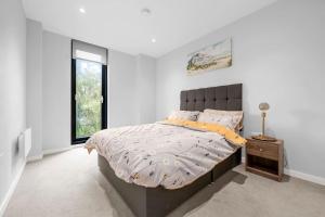 a bedroom with a large bed and a window at Manchester Haven Stylish Modern Apartment in Manchester