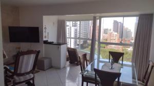 托雷斯APARTAMENTO SOLAR DA PRAÇA, Aconchegante e Climatizado的带桌椅和大窗户的客厅