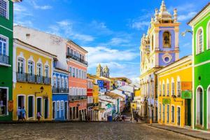 a city street with colorful buildings and a church at Apto Pelourinho Centro Histórico in Salvador
